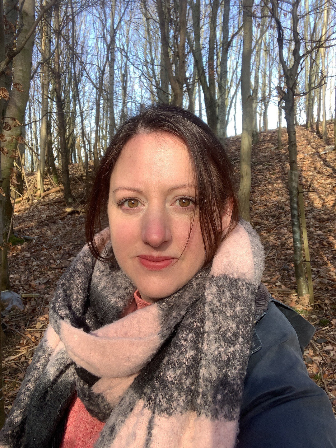 A close up photo of Laura, the owner of Eden Gift Co, standing in the woodland. At Eden Gift Co we specialise in personalised meaningful gifts.