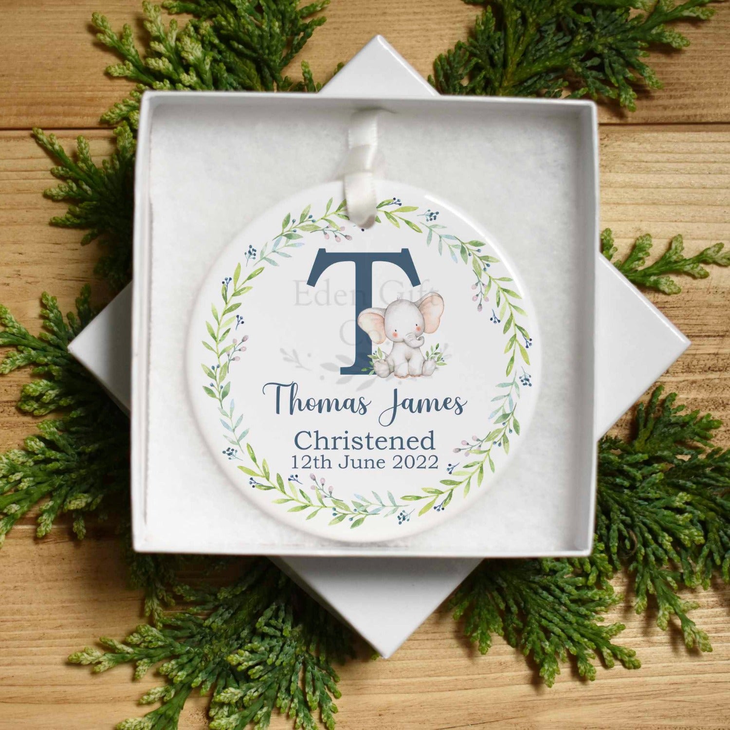 Image shows our ceramic keepsake with a cute watercolour elephant with a green foliage wreath. Name can be customised with the child's name and christening details. A lovely keepsake to remember a child / baby's christening. Text is in a navy font.