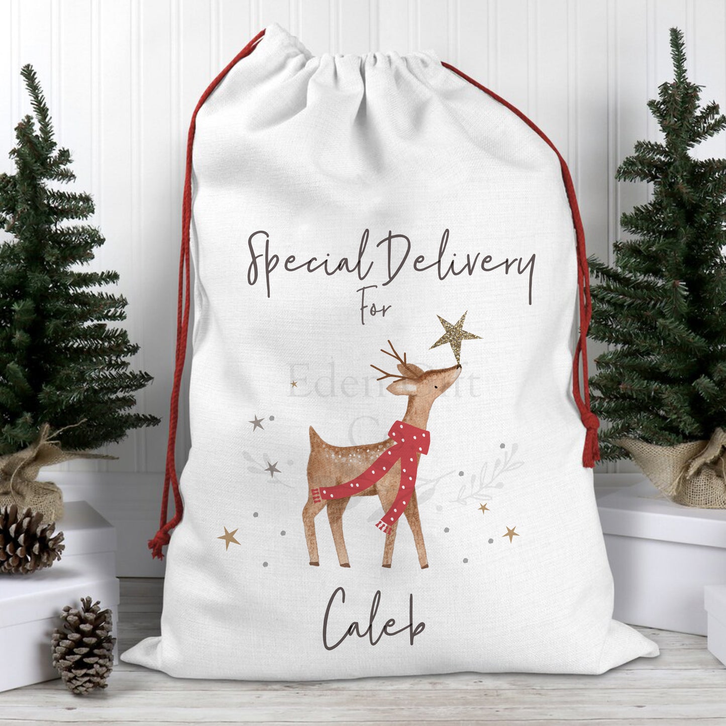 Our Linen Fabric, with red drawstring personalised santa sack with a cute, watercolour reindeer wearing a red spotted scarf. The reindeer is surrounded by gold starts, with a larger golden star balanced on his nose. This Christmas sack makes the perfect way to gift your presents under the tree, or use our small version to place your Christmas Pyjamas. 